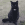 En sort kat, der sidder udendørs.