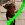 Un chien brun sur une brique de pavés sur le point de prendre un jouet à mâcher KONG vert dans sa gueule.